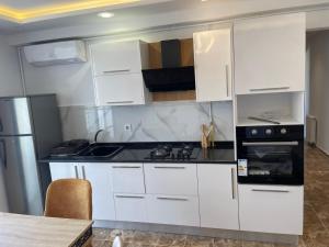 a kitchen with white cabinets and a stove top oven at Appartement s2 luxe tunis Jardins de Carthage in Tunis