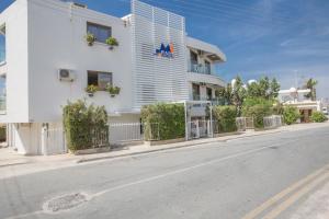 a white building on the side of a street at Ayia Napa Holiday Apartment So1 in Ayia Napa