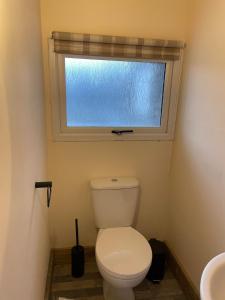 een badkamer met een wit toilet en een raam bij Boujie Barn- Stable in Waterfall