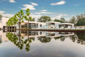 uma representação de uma casa com o seu reflexo na água em Natuurhuisje Bergvliet - Nature, Golf & Wellness em Oosterhout