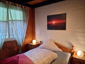 a bedroom with a bed and a picture of a sunset at Ferienhaus Martina in Extertal