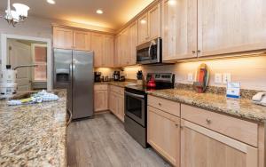 een keuken met houten kasten en roestvrijstalen apparatuur bij Jetty Life 473 home in Gulf Shores