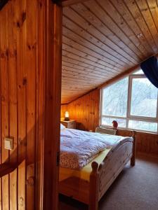 a bed in a wooden room with a window at Ferienhaus Martina in Extertal
