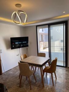 a dining room with a wooden table and chairs at Appartement s2 luxe tunis Jardins de Carthage in Tunis