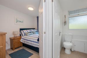 a bedroom with a bed and a toilet and a window at Chalet Seashell in Dartmouth