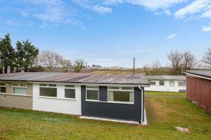 a house with a metal roof on a yard at Chalet Seashell in Dartmouth