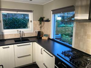 a kitchen with a black counter top and a window at Natuurhuisje Bergvliet - Nature, Golf & Wellness in Oosterhout