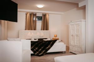 sypialnia z białym łóżkiem z czarnym kocem w obiekcie Chalet Austria, up to 10 p, 15 min to salzburg city, garden with direct amazing mountainview, BBQ&bikes&sunbeds for free, 15 min sound of music w mieście Golling an der Salzach
