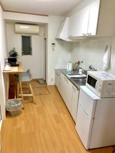 uma pequena cozinha com um lavatório e um micro-ondas em 花楓舎-Sakura & Maple Guest House-ゲストハウス em Quioto