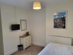 a bedroom with a bed and a tv on a wall at The Bird in Hand in Stourport
