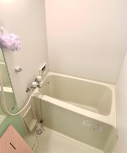 uma banheira branca na casa de banho com em 花楓舎-Sakura & Maple Guest House-ゲストハウス em Quioto