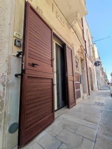 una grande porta di legno sul lato di un edificio di La dimora nel sottano alla strada a Polignano a Mare