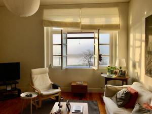 salon z kanapą i oknem w obiekcie Alcacer River Apartment w mieście Alcácer do Sal