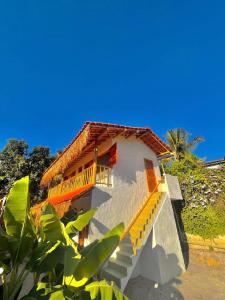 un edificio con escaleras que conducen a él con una palmera en Casa Jandaia Trancoso - apartamento superior, en Trancoso