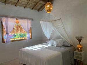 a bedroom with a bed with a mosquito net at Casa Jandaia Trancoso - apartamento superior in Trancoso