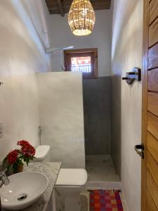 a bathroom with a sink and a toilet and a mirror at Casa Jandaia Trancoso - apartamento superior in Trancoso