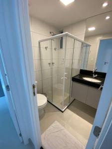 La salle de bains est pourvue d'une douche en verre et de toilettes. dans l'établissement Edifício Promenade II Apt 1108 -Mandi Hospitalidade, à Maceió