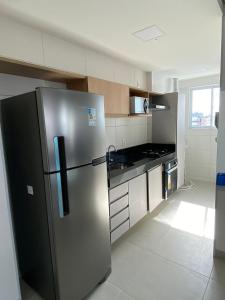 Il comprend une cuisine équipée d'un réfrigérateur en acier inoxydable et d'une cuisinière. dans l'établissement Edifício Promenade II Apt 1108 -Mandi Hospitalidade, à Maceió