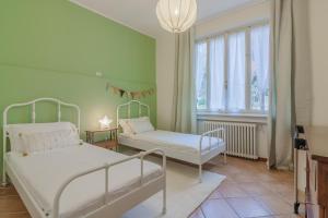 een kamer met 2 bedden en een raam bij Villa Gard by Wonderful Italy in Bellagio