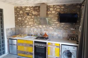 a kitchen with a sink and a washing machine at studio en pierres traditionnelle in Essaouira