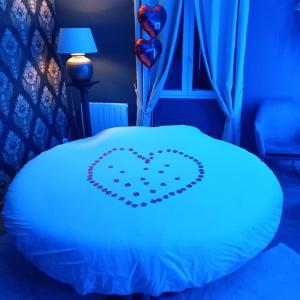 Una cama con un corazón dibujado en ella en Suite privée avec BALNEO (Jacuzzi ou baignoire)., en Yvetot