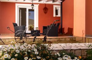 a patio with chairs and flowers in front of a building at Mistral Apartments in Lopar