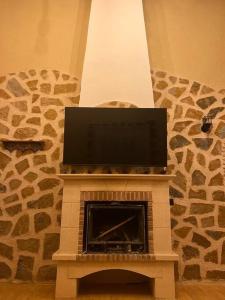 y chimenea con TV de pantalla plana. en Villa parque natural, en Murcia