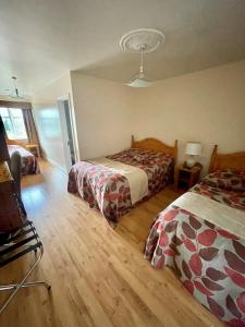 1 dormitorio con 2 camas y suelo de madera en GoldenDawn Guest House, en Citywest