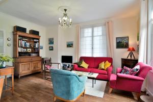 a living room with a red couch and chairs at Ile Celée - Maison de caractère proche plage in Dinard