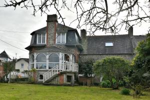 Cette maison ancienne dispose d'une terrasse couverte blanche et d'une cheminée. dans l'établissement Ile Celée - Maison de caractère proche plage, à Dinard