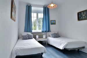 Cette chambre comprend 2 lits et une fenêtre. dans l'établissement Ile Celée - Maison de caractère proche plage, à Dinard