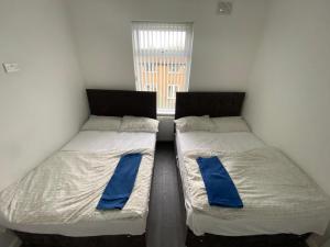 two twin beds in a room with a window at Entire Holiday Home in Mirfield