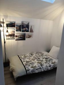 a bedroom with a bed with pictures on the wall at MAISON NGP in Aigueblanche