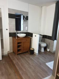 łazienka z umywalką i toaletą oraz telewizor w obiekcie MAISON NGP w mieście Aigueblanche