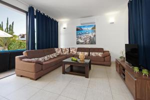 Sala de estar con 2 sofás y TV en Villa Ingrid, en Ayia Napa