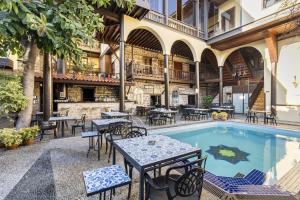 un patio extérieur avec des tables et des chaises à côté d'une piscine dans l'établissement Cozy Studio Flat near Hadrians Gate, à Antalya