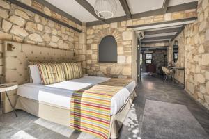 1 dormitorio con cama y pared de piedra en Charming Flat near Hadrians Gate, en Antalya