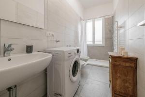 a white bathroom with a washing machine and a sink at Realkasa Fiera District Flat in Bologna