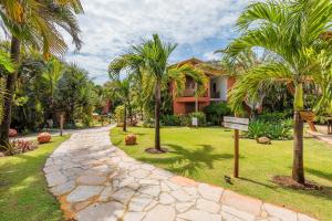 a walkway in front of a house with palm trees at Aruanã Eco Praia Hotel in Aracaju