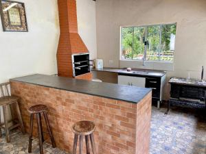 a kitchen with a brick bar and a brick oven at Chácara das Suculentas in Mairiporã