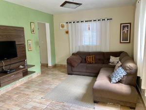 a living room with a couch and a flat screen tv at Chácara das Suculentas in Mairiporã
