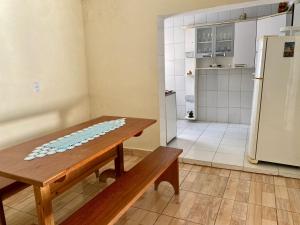 a kitchen with a wooden table and a refrigerator at Chácara das Suculentas in Mairiporã
