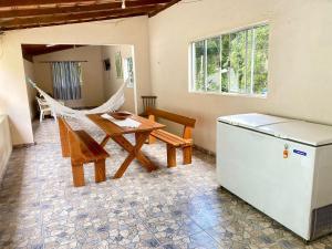 a kitchen with a table and a hammock and a refrigerator at Chácara das Suculentas in Mairiporã