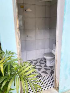 a bathroom with a toilet and a black and white tile floor at Chácara das Suculentas in Mairiporã