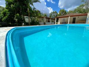 a large blue swimming pool in front of a house at Chácara das Suculentas in Mairiporã