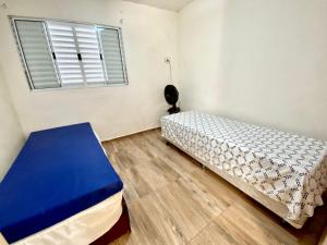 1 dormitorio con 2 camas y ventana en Chácara das Suculentas, en Mairiporã