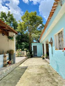 une cour d'une maison avec un bâtiment bleu dans l'établissement Chácara das Suculentas, à Mairiporã