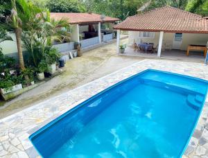 a large blue swimming pool in front of a house at Chácara das Suculentas in Mairiporã