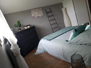 ein Schlafzimmer mit einem Bett und einer Leiter an der Wand in der Unterkunft Gîte cocooning avec piscine in Bougé-Chambalud
