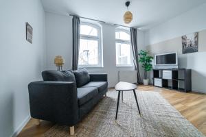 a living room with a couch and a tv at Full House Apartment MCity L10 in Magdeburg
